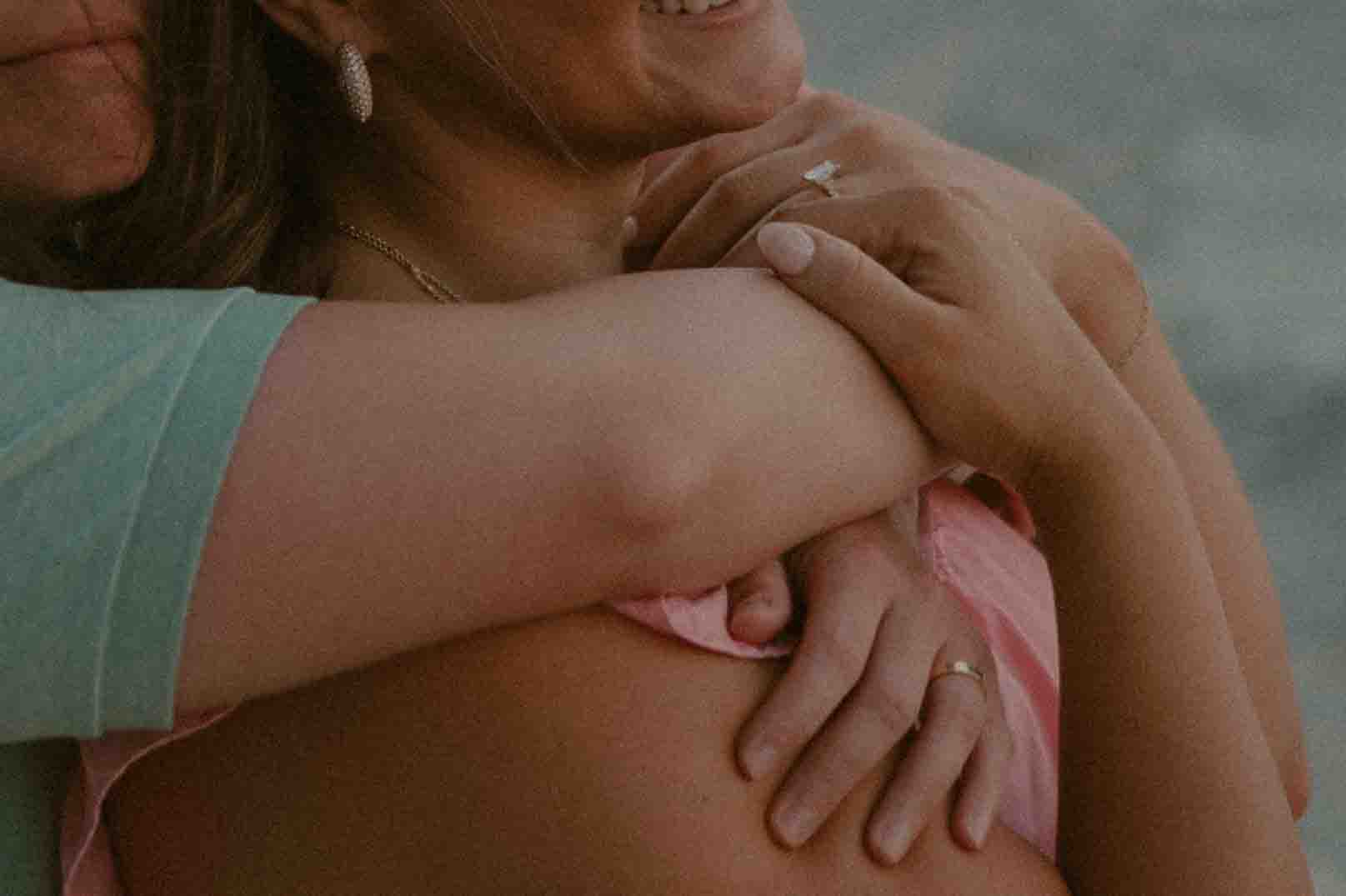 couple hugging at the beach during their engagement session at Fontainebleau State Park.