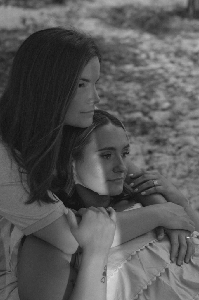 Couple sitting on log looking at the sunset during their engagement session at Fontainebleau State Park.
