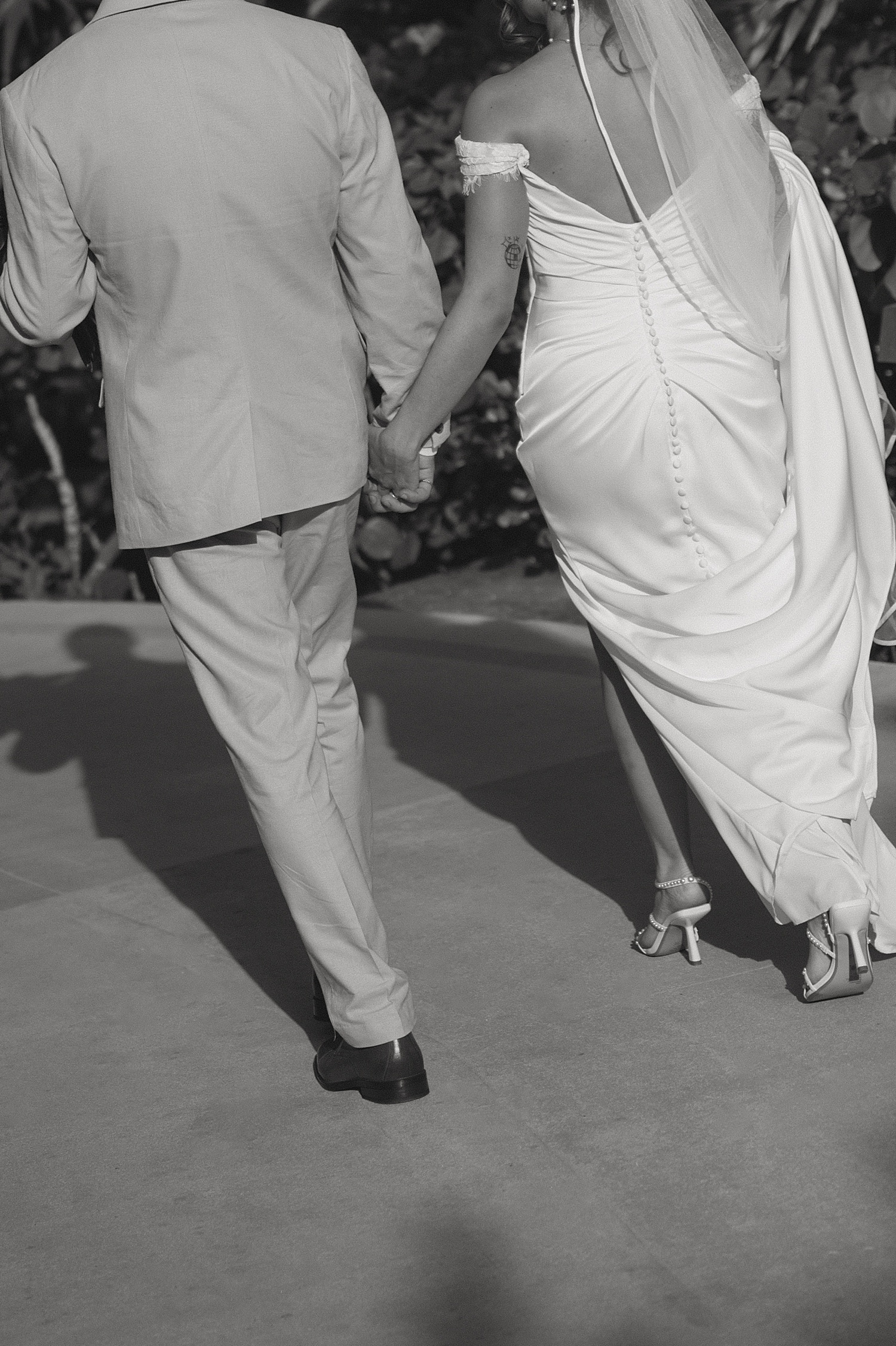 husband and wife walk hand in hand on resort sidewalk by Travel Elopement Photographer