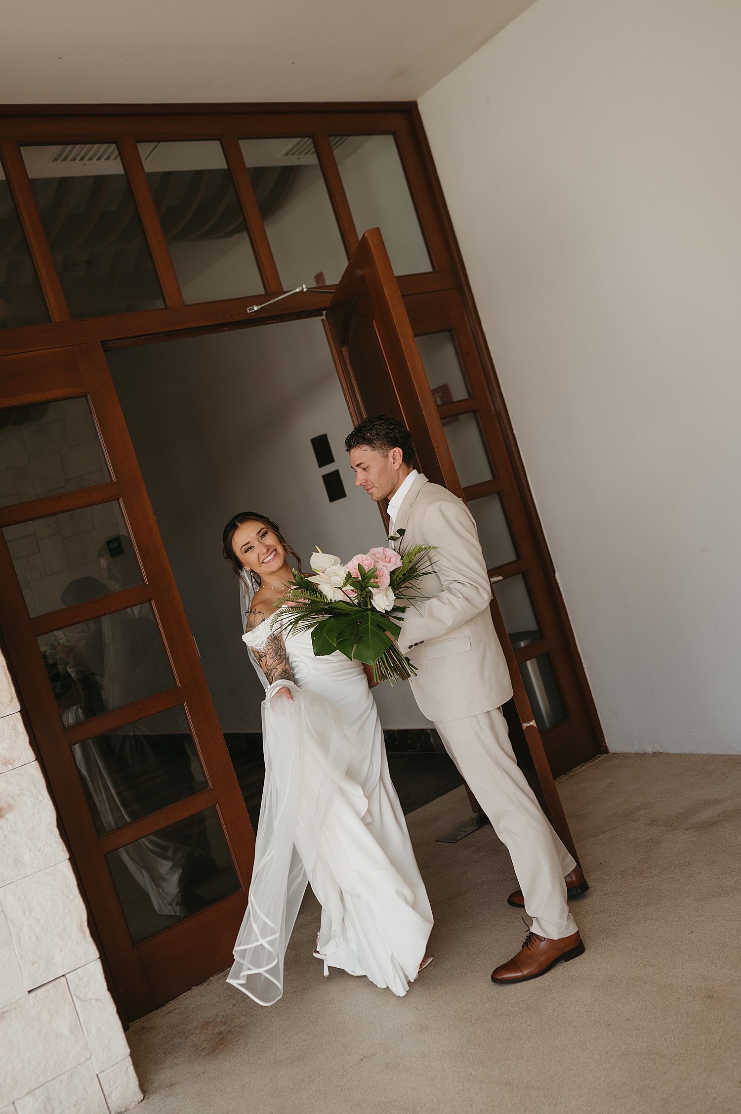 couple walks into large wooden doors at Dreams Playa Mujeres