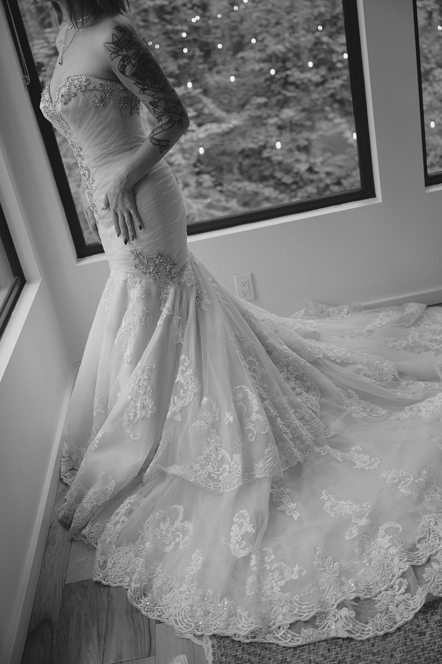 bride in long white dress stands next to pocket windows for vow renewal