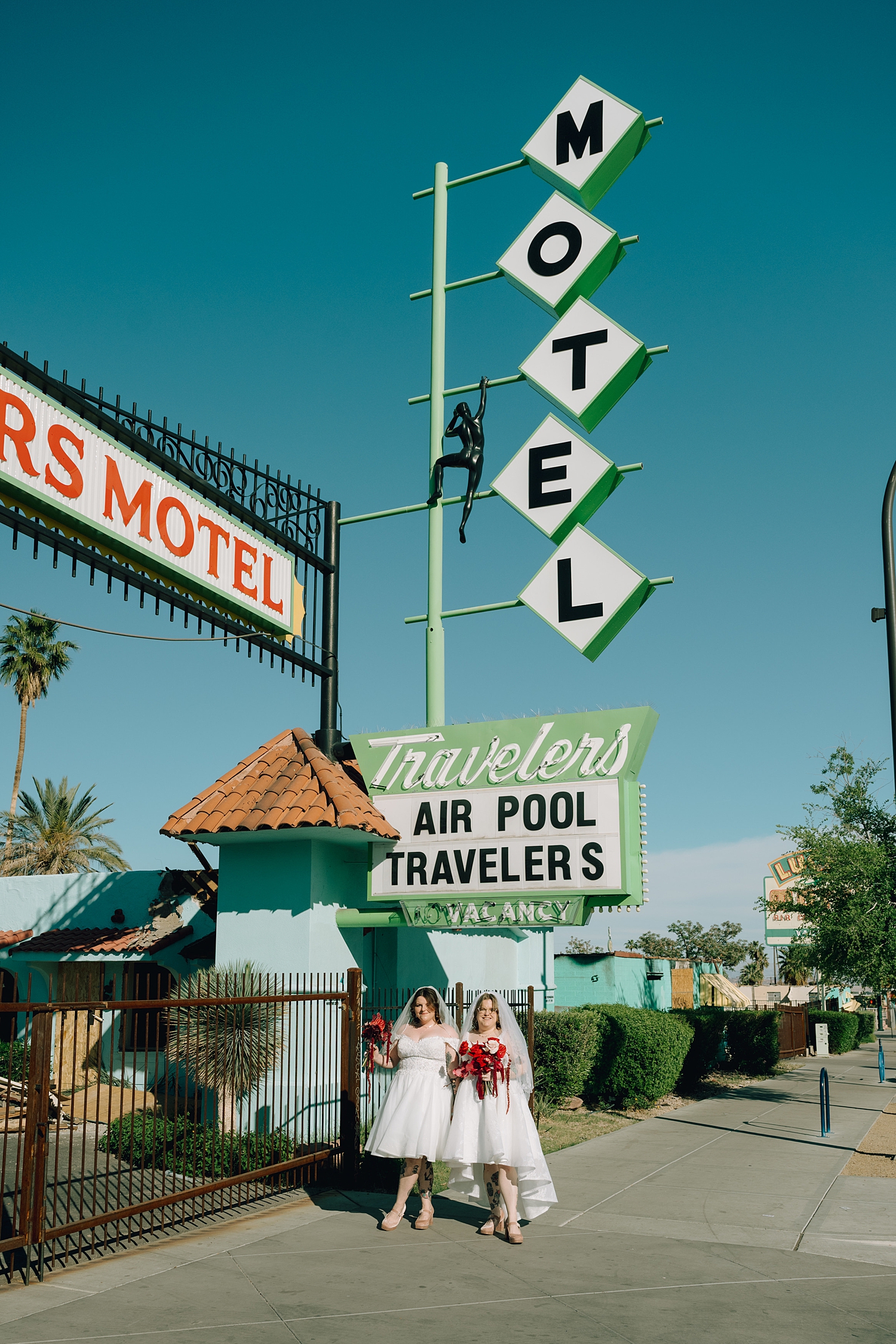 couple stands under motel sign before big day at Sure Thing Chapel
