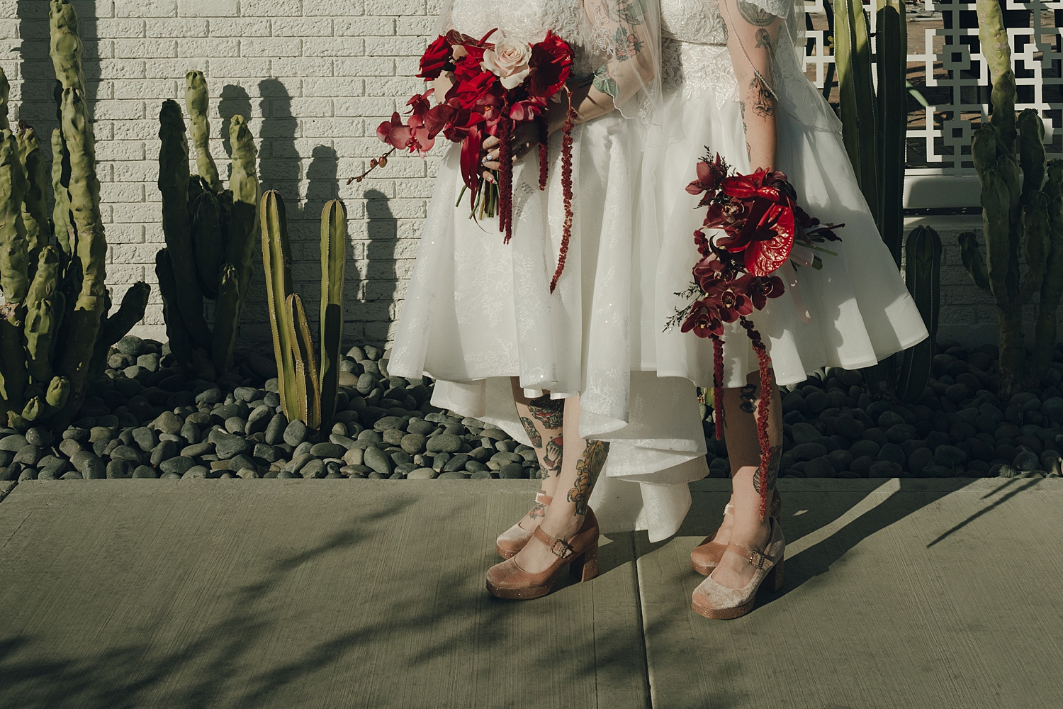 brides walk hand in hand down sidewalk by Thistle and Veil Photo