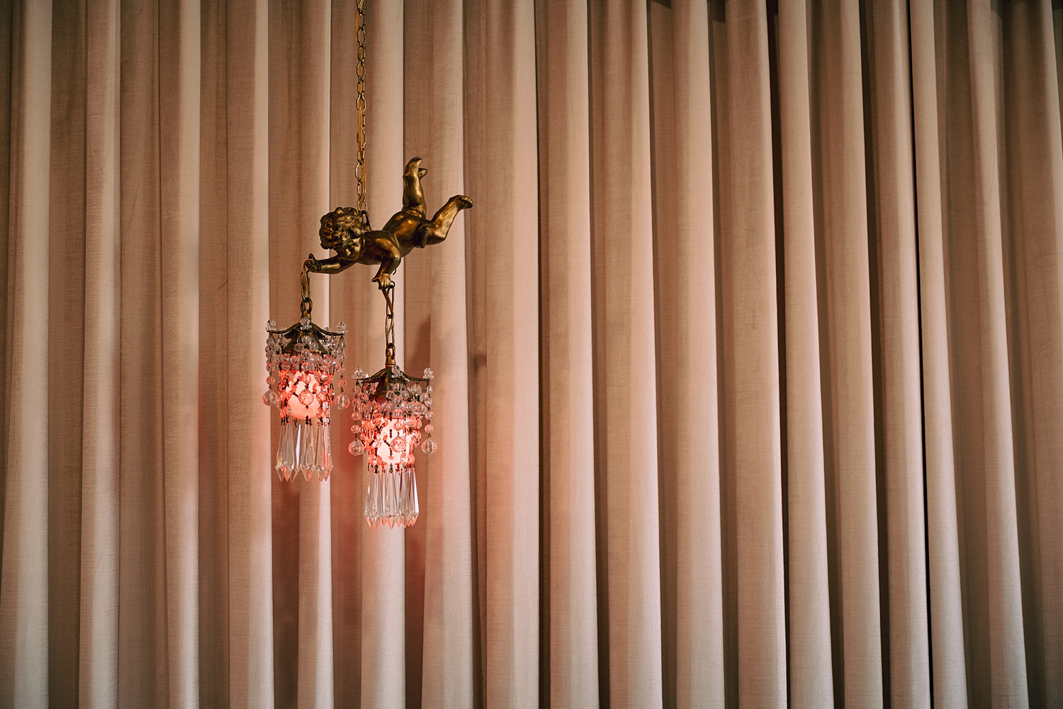 Chandelier hanging in front of curtains at sure thing chapel