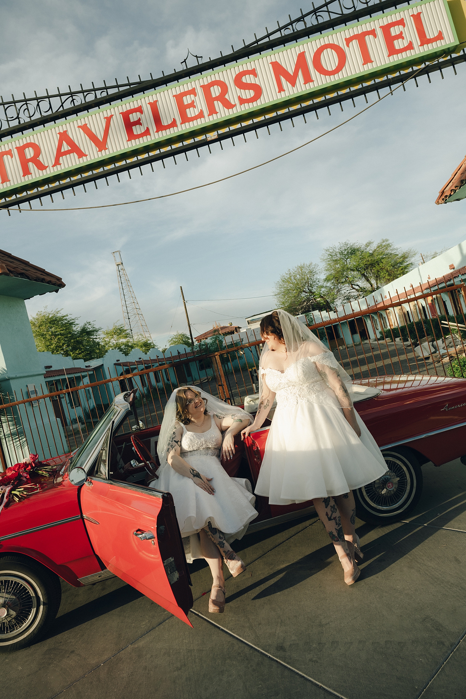 two women hold hands over red vintage car by Thistle and Veil Photo