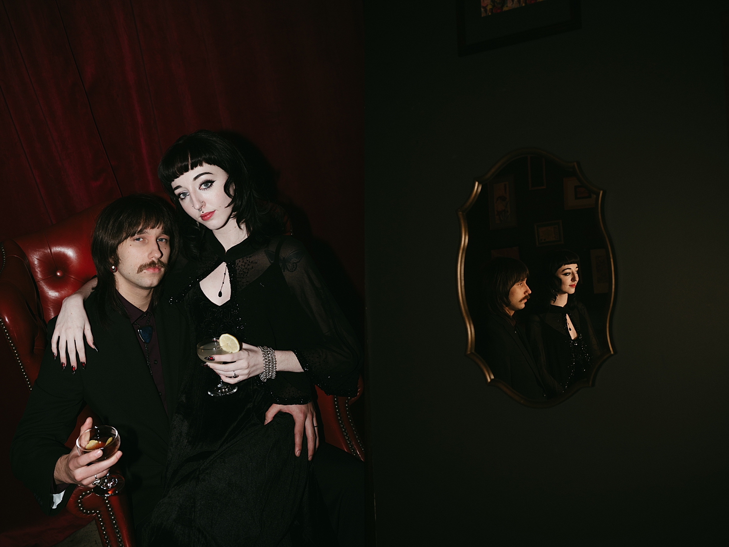 goth couple holds cocktails in lounge by travel elopement photographer