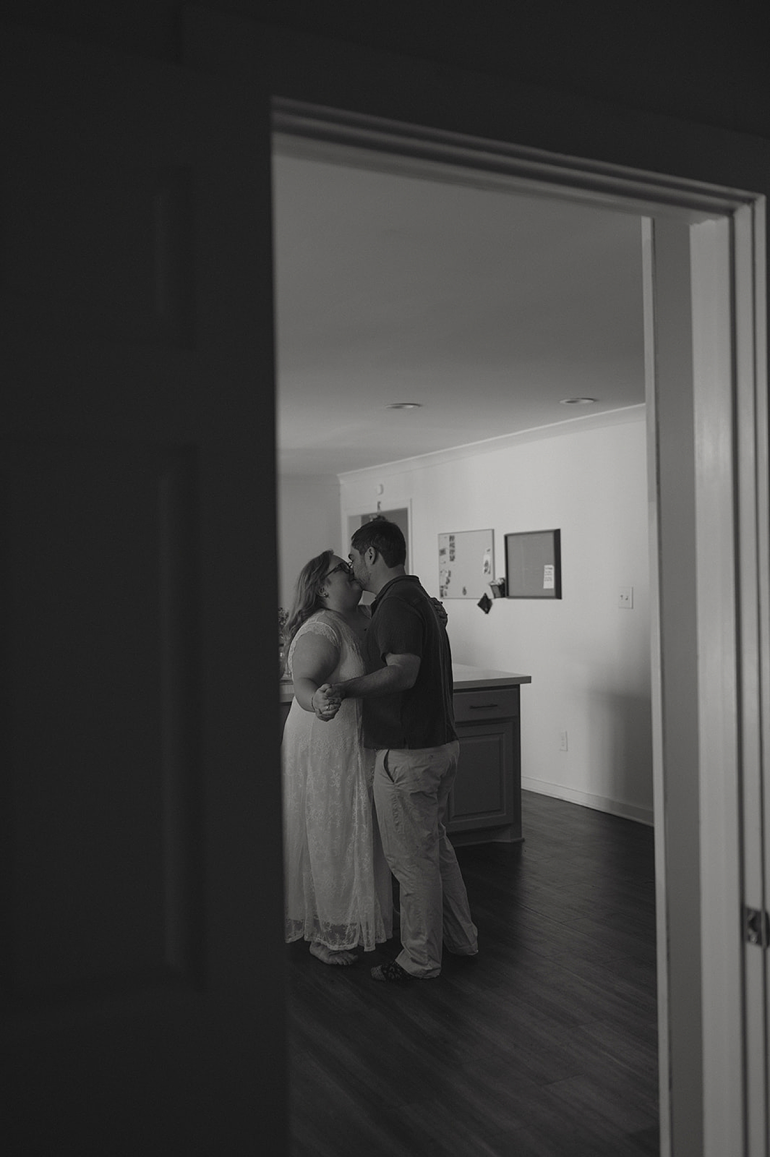 man kisses his wife-to-be in their living room by Thistle and Veil Photography