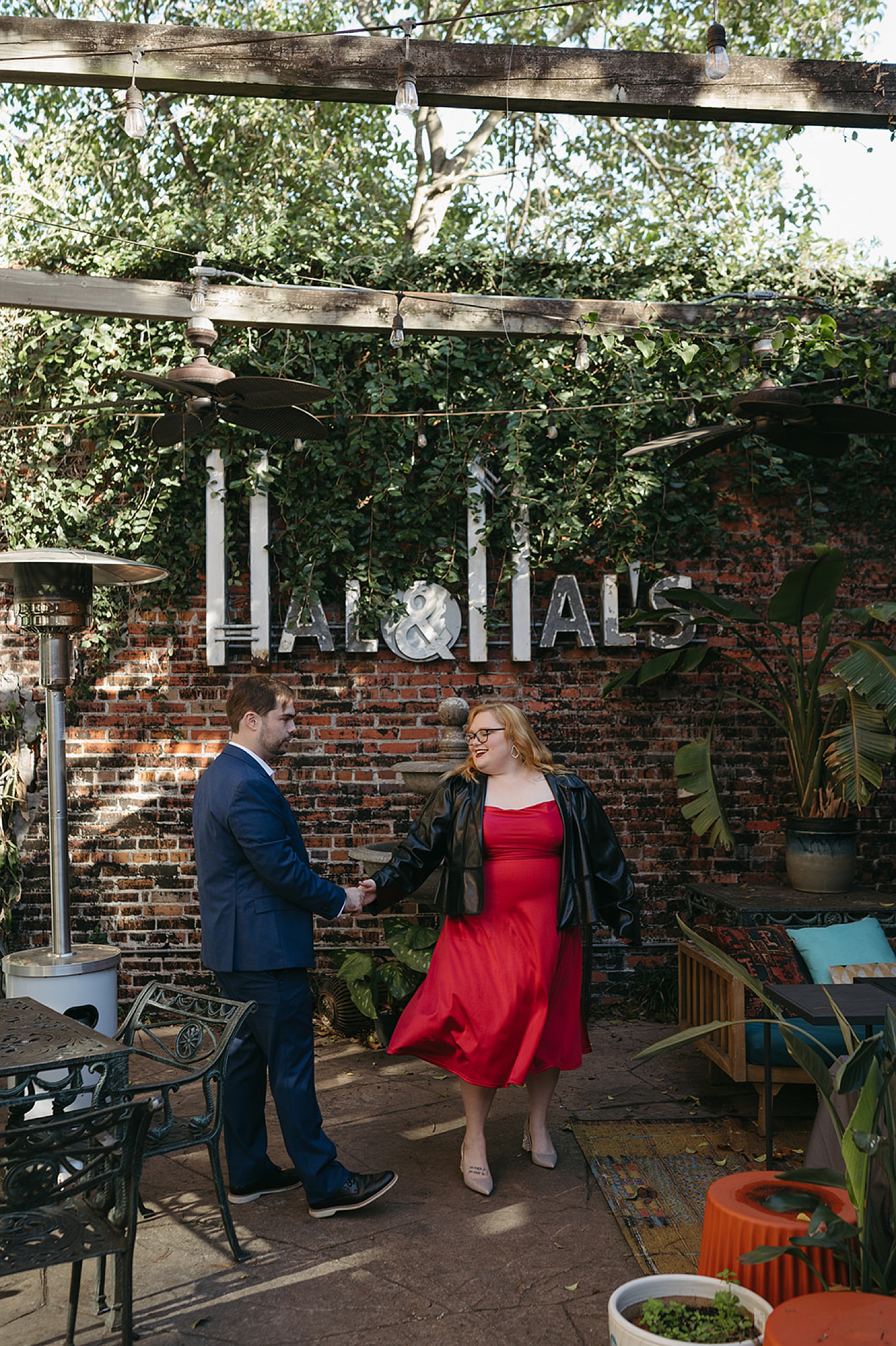 couple dances under coffee shop sign by Thistle and Veil Photography